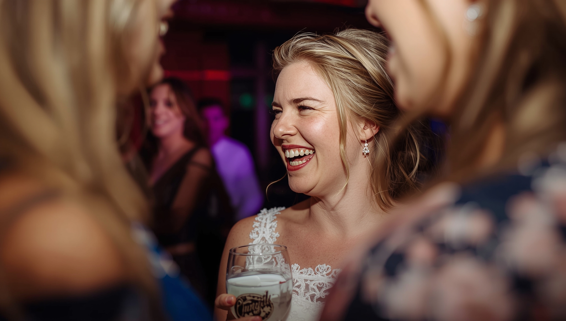 Close-up of a bride laughing with friends during at westend wedding reception.